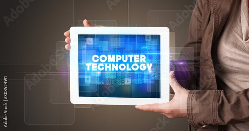 Wallpaper Mural Young business person working on tablet and shows the inscription: COMPUTER TECHNOLOGY Torontodigital.ca