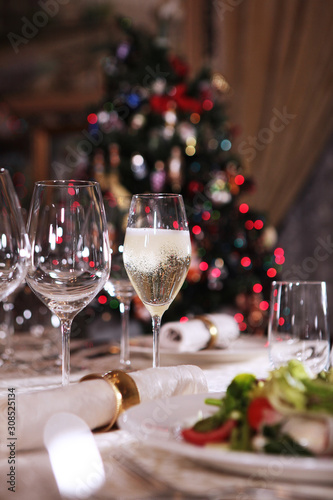 A glass of champagne is on the table. The celebration of New year or Christmas. Copy space.