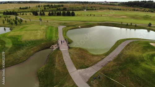 drone flies over a golf course photo