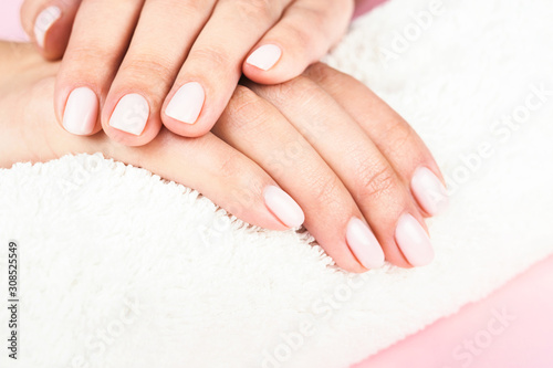 Female's hands with classic pastel manicure.