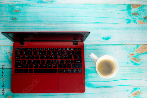 Kawa i laptop na turkusowym drewnianym tle