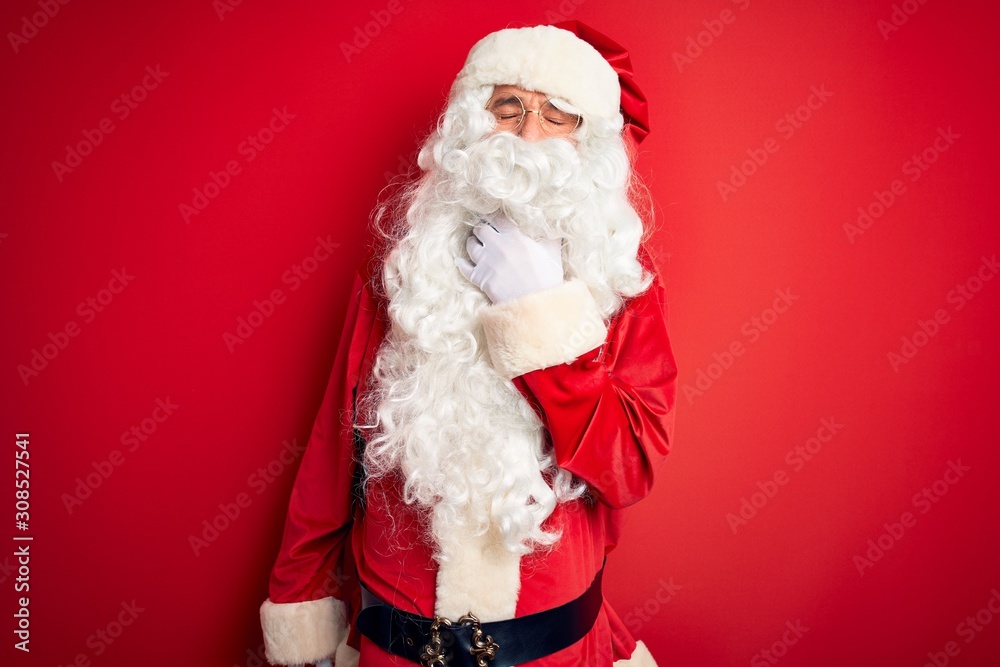 Middle age handsome man wearing Santa costume standing over isolated red background Touching painful neck, sore throat for flu, clod and infection