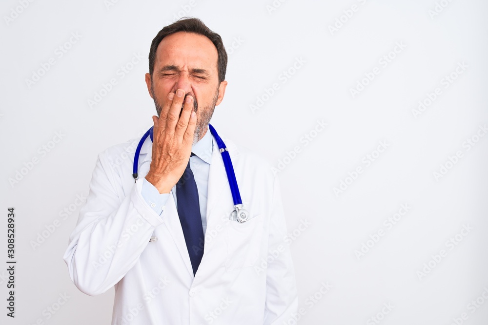 Middle age doctor man wearing coat and stethoscope standing over isolated white background bored yawning tired covering mouth with hand. Restless and sleepiness. Middle age doctor man wearing coat and stethoscope standing over isolated white background bored yawning tired covering mouth with hand. Restless and sleepiness.