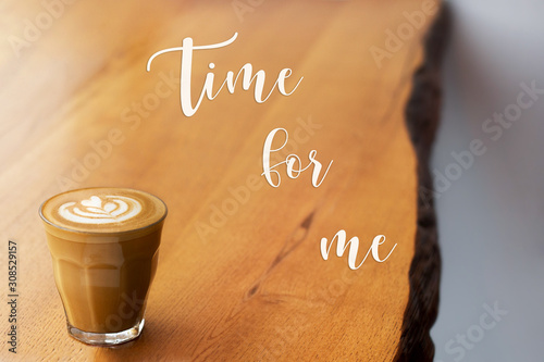Time for me. Glass with coffee on a wooden table. Cappuccino with almond milk. Vegetarian drink. Relax with a cup of coffee