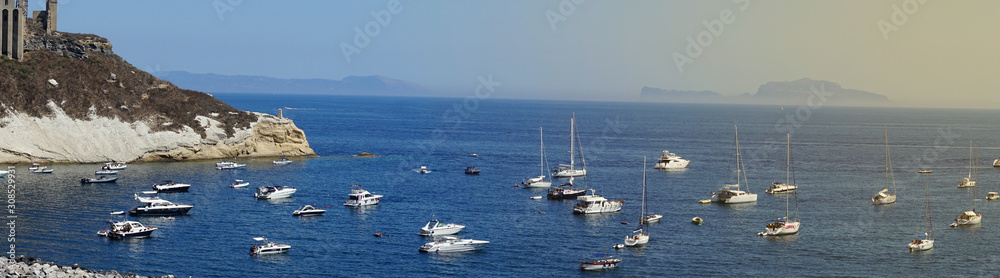 Panoramic view of fishing boats and yachts, clear blue sky and the azure sea on the island of Procida, Italy. Near Napoli