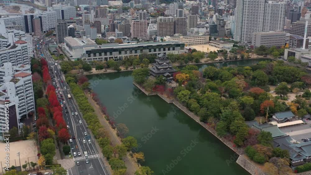Aerial view of park of Hiroshima Castle, modern city of Hiroshima in background, picturesque autumn scenery with colorful trees - landscape panorama of Japan from above, Asia Aerial view of park of Hiroshima Castle, modern city of Hiroshima in background, picturesque autumn scenery with colorful trees - landscape panorama of Japan from above, Asia