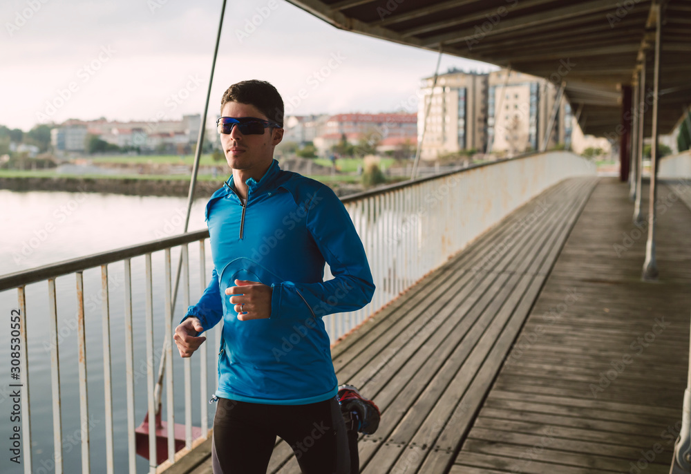 Spain, Naron, jogger running on a wooden bridge Spain, Naron, jogger running on a wooden bridge