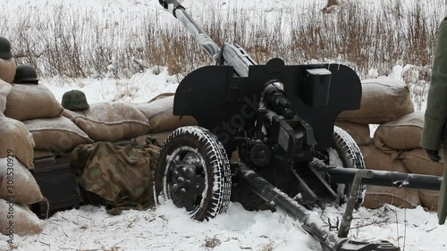 artillery gun and artilleryman in the fighting position in the winter photo