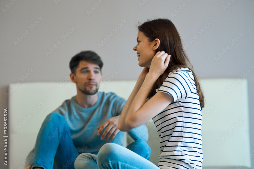 young couple sitting on sofa and looking at camera young couple sitting on sofa and looking at camera