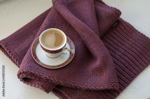 A Cup of coffee on a burgundy canvas