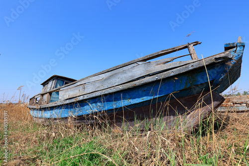 The broken wooden boat is on land