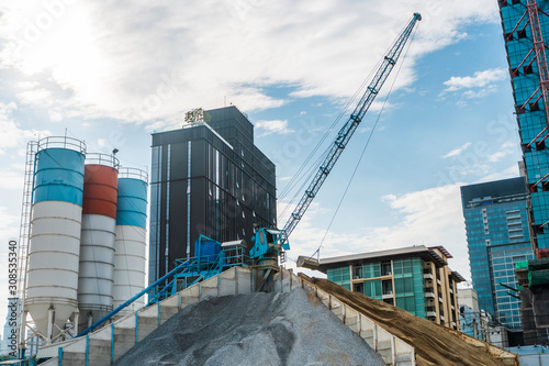 Blue crane on a modern construction site. Construction crane on a constructin site. Crane machine stand by waiting for work under the construction building. Heavy industry. photo