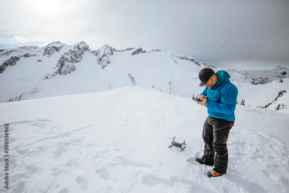 Man preparing to use drone on snow covered mountain. Man preparing to use drone on snow covered mountain.