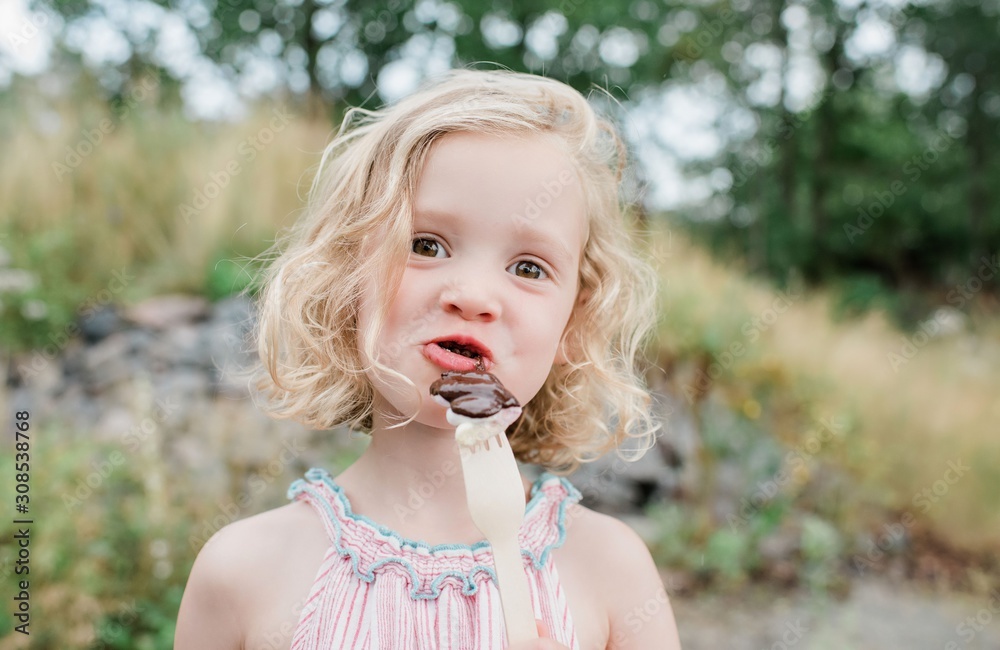 fun portrait of a young girl eating chocolate and marshmallows fun portrait of a young girl eating chocolate and marshmallows