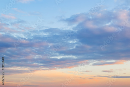 Golden blue sunset sky with light clouds. Vanilla sky. Tranquil skyscape just before the sundown. Pastel scenic cloudscape for background.