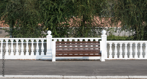 stone fence fence with balusters and bench in front walking area