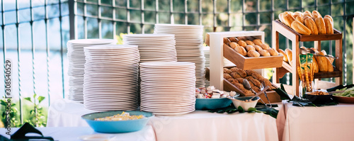 Obraz na plátně Table full of fresh bread and empty dishes ready for people enjoying the caterin