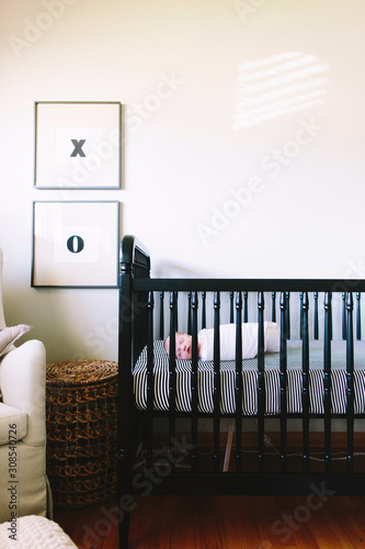 A baby boy sleeping in his crib in a modern nursery photo