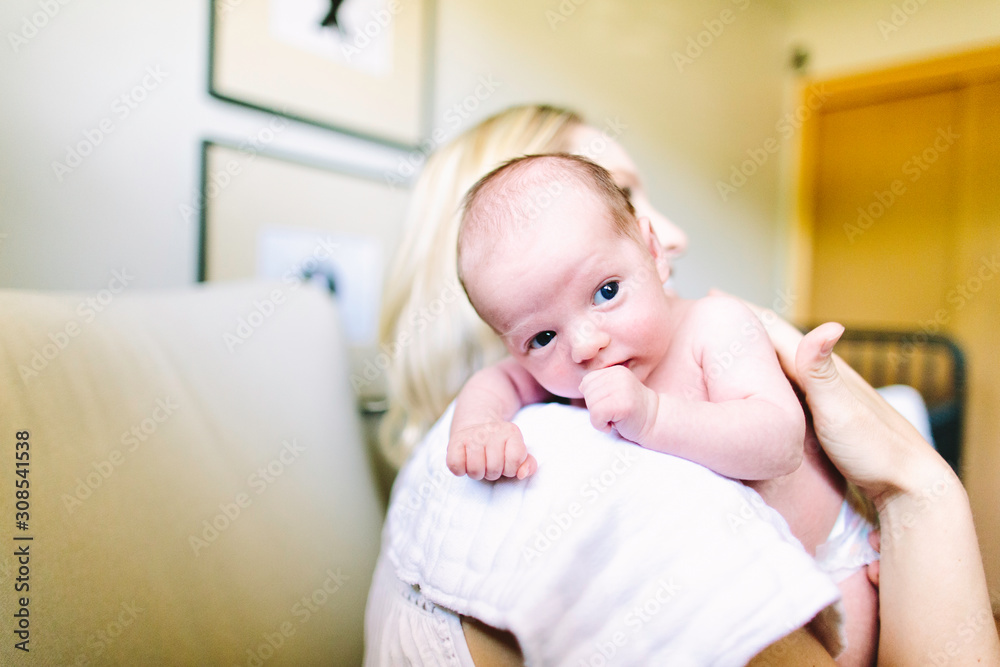 Side view of a first time mother holding her newborn baby boy Side view of a first time mother holding her newborn baby boy