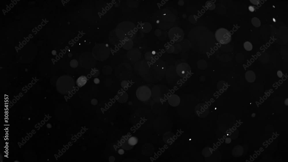 Slow motion of natural organic dust particles on black background. Filmed on high speed cinema camera