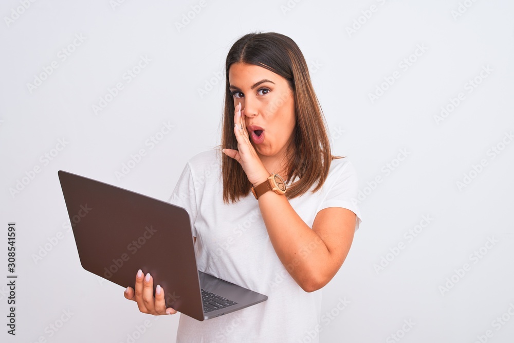 Beautiful young woman working using computer laptop over white background hand on mouth telling secret rumor, whispering malicious talk conversation Beautiful young woman working using computer laptop over white background hand on mouth telling secret rumor, whispering malicious talk conversation