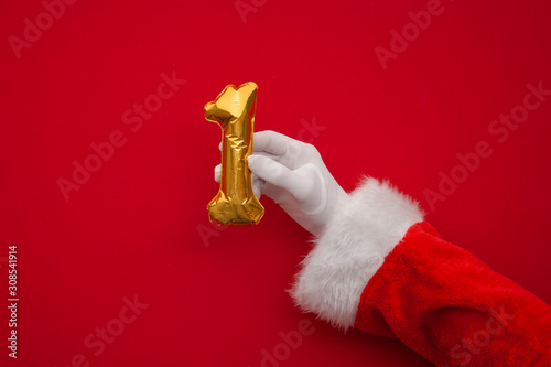 12 days of christmas. Santa hands holding 1st day balloon on red background photo