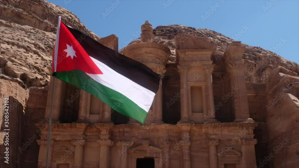The Jordan flag on backround of The Monastery,  in Petra, Jordan.