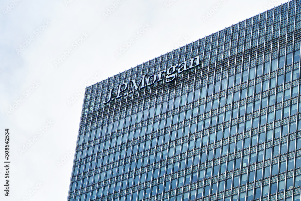 Foto Stock London, United Kingdom - February 03, 2019: Sun shines on J P  Morgan signage at top of their UK branch at Canary Wharf. JPMorgan Chase is  US multinational investment bank