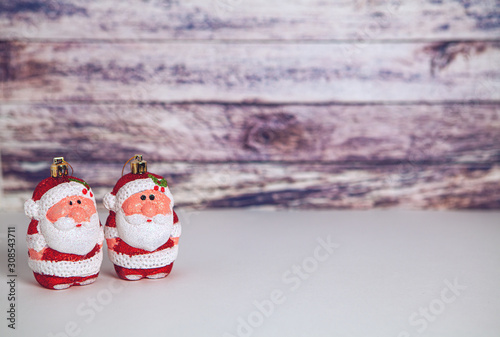 Two santa claus on white floor and wooden background for new year and christmas
