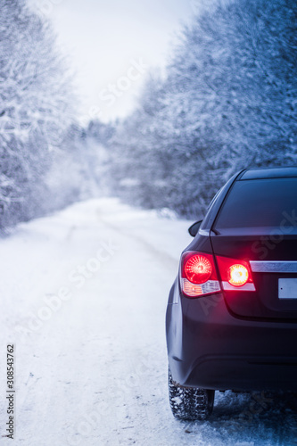 Car in winter in nature outside the city. Snow picture. Snow on the road. Winter road. The white trees. Black car. The car on the road. © alenka2194