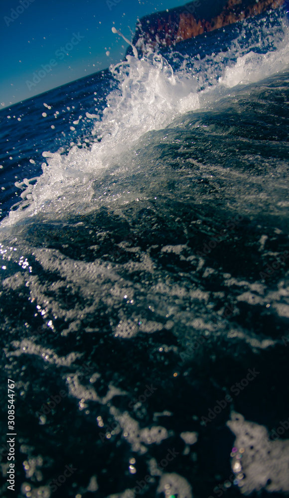 Splashes from the yacht in the sea water. Wake of a ferry boat