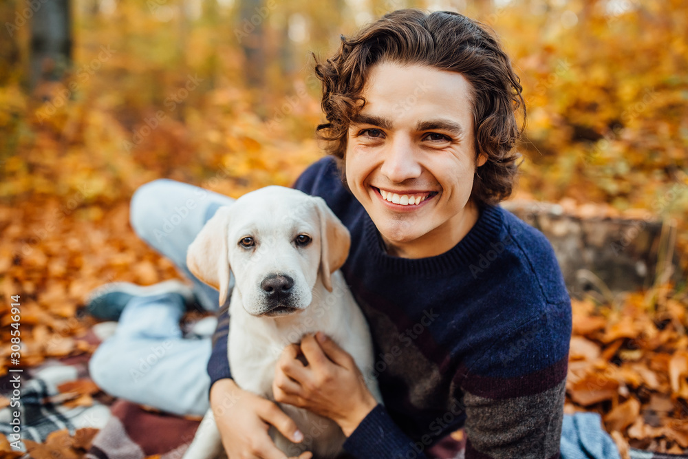 Photo of happyman and his labrador playing together in the autumn forest. Photo of happyman and his labrador playing together in the autumn forest.
