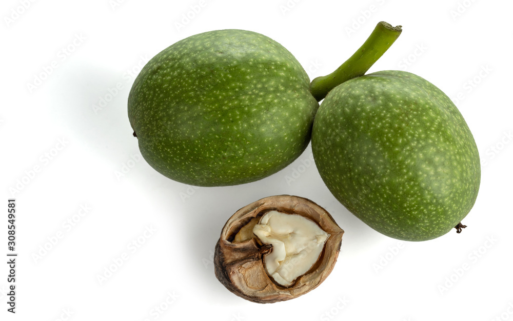 Young walnuts in green husks and with cracked shells. Isolated on white background. Young walnuts in green husks and with cracked shells. Isolated on white background.
