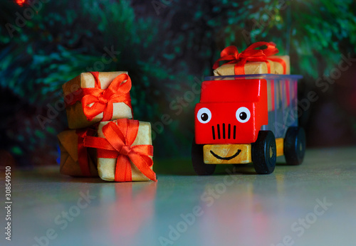 Tableau sur toile Red children's toy car with gift boxes with a red bow under the Christmas tree