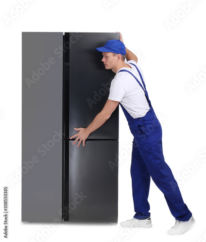 Professional worker carrying refrigerator on white background