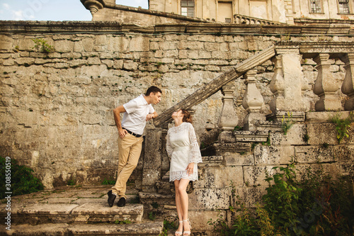Charming and fashionable couple in love on the background of old vintage castle