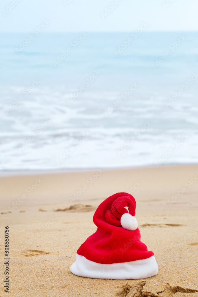 Santa Claus red hat on the sandy ocean Santa Claus red hat on the sandy ocean