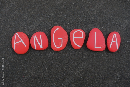 Angela, female given name composed with red colored and carved stone letters over black volcanic sand photo