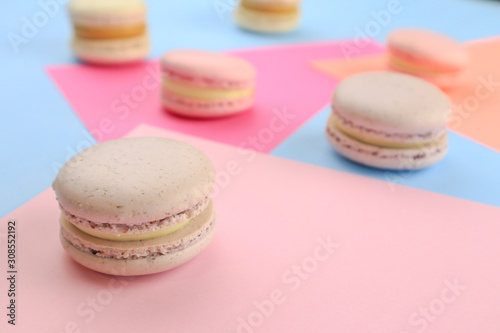 Tasty sweet macaron cakes on color background