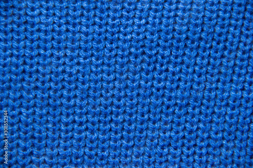 Knit close-up. Colored knitted wool close-up. Blue background