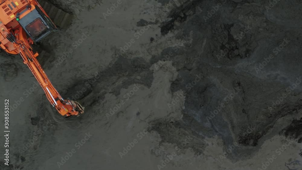 Top down aerial view of a digger mud on a construction site.