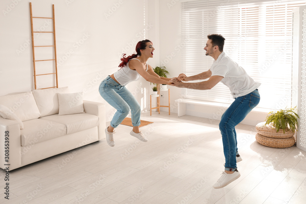 Beautiful young couple dancing in living room Beautiful young couple dancing in living room