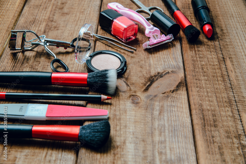 A set of cosmetics on a wooden table. The concept of doing makeup, caring for the appearance of women. Applying brushes, eye shadows, powder. A set of cosmetics on a wooden table. The concept of doing makeup, caring for the appearance of women. Applying brushes, eye shadows, powder.