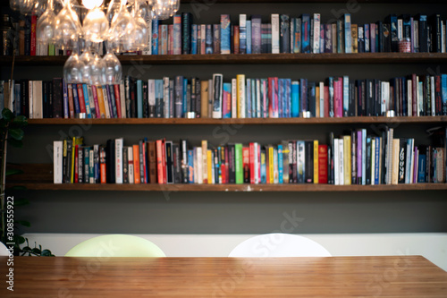 Coloful wall with many books on book shelves in a modern living room blurred,...
