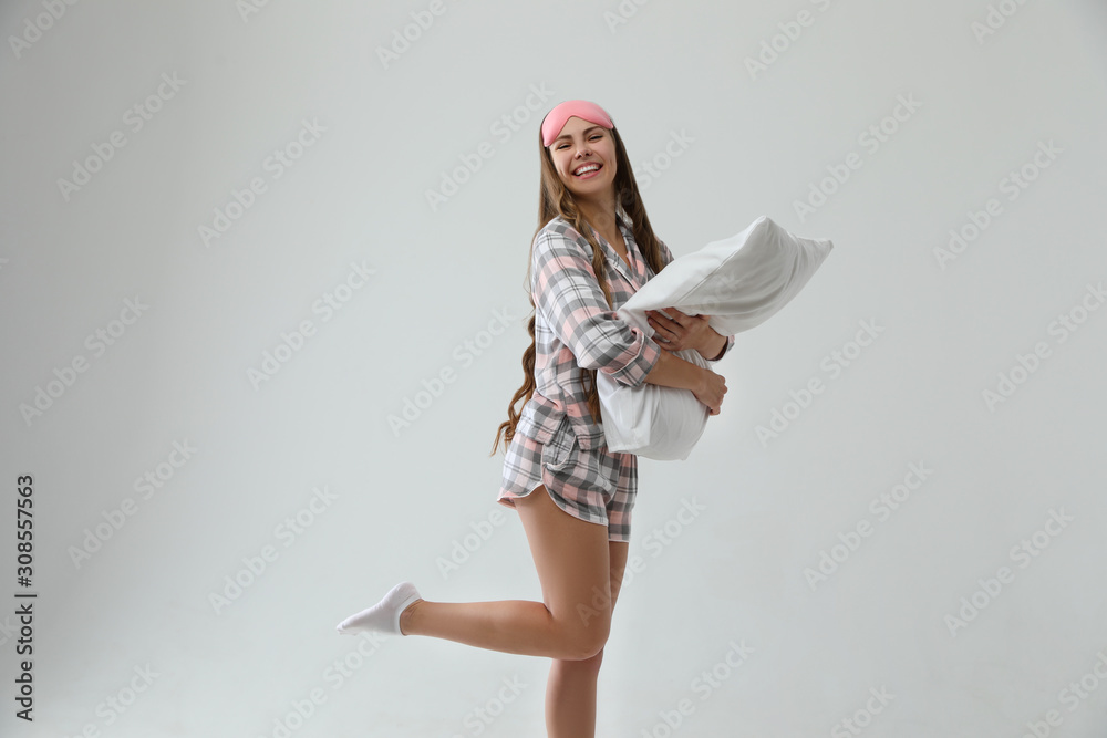 Beautiful woman with pillow on light grey background. Bedtime Beautiful woman with pillow on light grey background. Bedtime