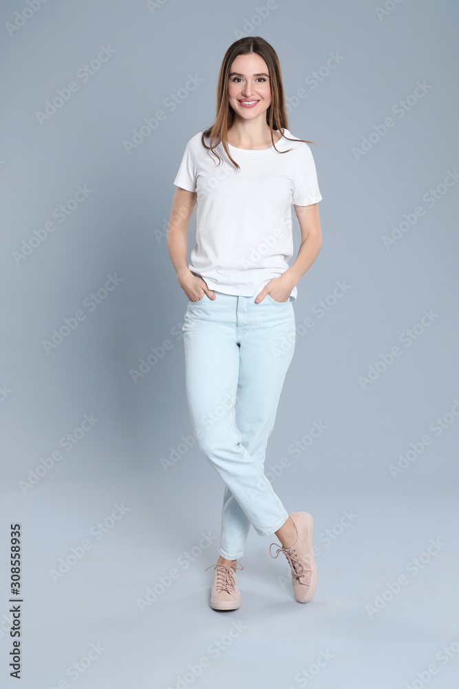 Young woman in stylish jeans on grey background Young woman in stylish jeans on grey background