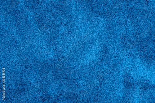 Texture of coastal wet sea sand toned in classic blue. Color of the year 2020. Colorful concept.