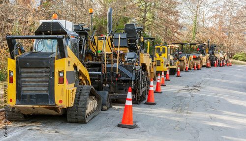 Foto Long line of asphalt pavers and rollers parked on neighborhood street