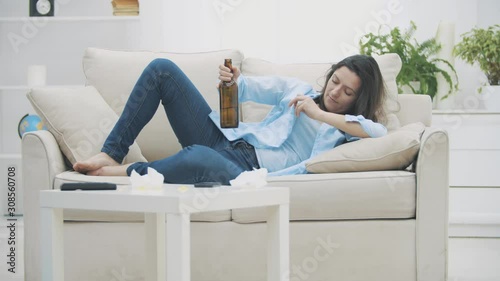 Slowmo. Tipsy brunette woman is holding a bottle of beer and drinking beverage. 4K.