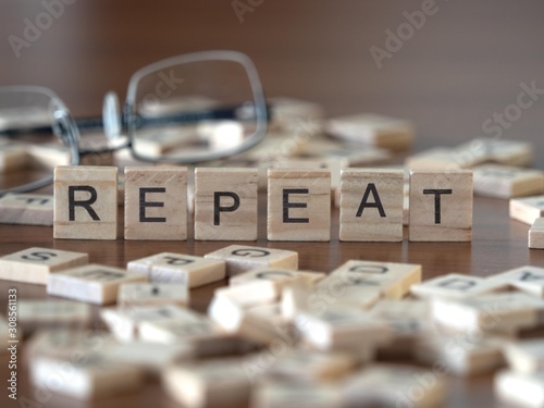 repeat the word or concept represented by wooden letter tiles photo